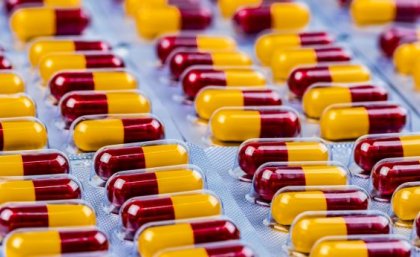 Rows of maroon and yellow capsule medication in blister packs